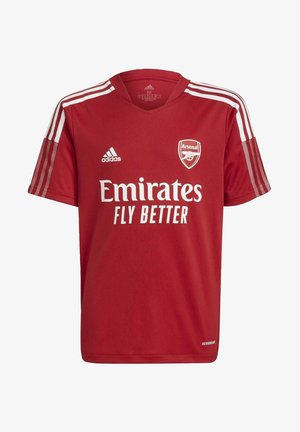 Czerwona koszulka piłkarska Arsenal z białym logo Adidas, trzema białymi paskami na ramionach oraz napisem sponsora "Emirates Fly Better".