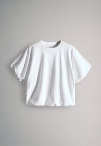 Hvid kortærmet oversized T-shirt med rund halsudskæring vist mod en lysegrå baggrund.