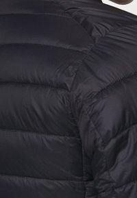 Kurtka puchowa w matowej czerni, z poziomymi, pikowanymi sekcjami, gładką powierzchnią oraz wysokim kołnierzem dla dodatkowego ciepła.