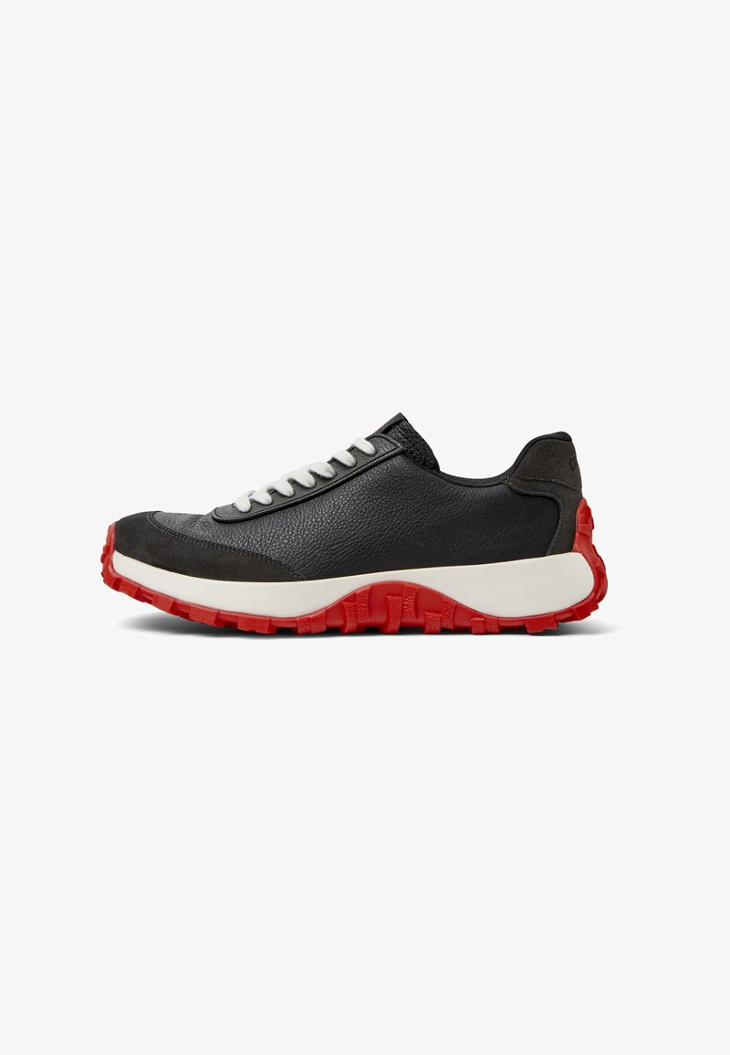 Sneaker in pelle nera con lacci grigio chiaro, tomaia texturizzata e suola in gomma rossa spessa con un motivo battistrada per migliorare la trazione.