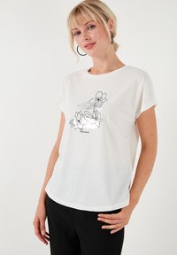 Hvid kortærmet T-shirt med et sort blomstermotiv og teksten "Floraison." Stoffet har en blød struktur; afslappet pasform.