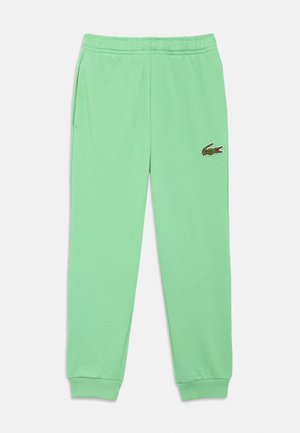Green cotton sweatpants featuring an elastic waistband, side pockets, ribbed cuffs, and a small embroidered logo on the thigh.