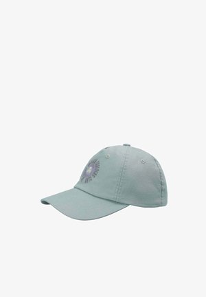 Gorra de béisbol azul claro con visera curva y un diseño de logo circular que incluye texto y un pequeño icono central en el panel frontal.