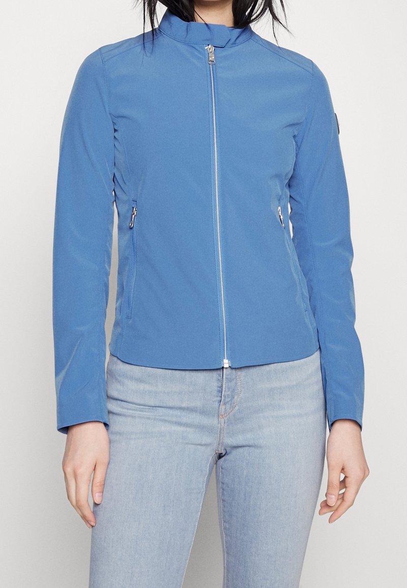 Blue lightweight jacket with a high collar, front zipper, and two side pockets. Smooth texture, fitted design, and long sleeves.