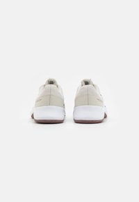 Sneaker con tomaia in mesh crema, suola intermedia bianca e suola esterna in gomma marrone. Presenta un colletto e un tassello sul tallone imbottiti, con il marchio sui lati.