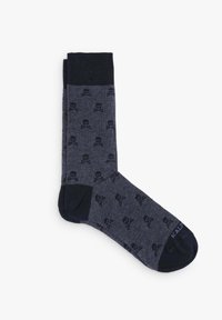 Calcetines azul oscuro con un patrón de calaveras, que cuentan con un cuerpo texturizado y un puño sólido en azul marino oscuro. Punta y talón reforzados para mayor durabilidad.