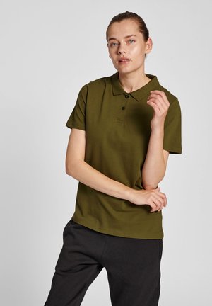 Olijfgroene polo met een klassieke kraag, drie-knoopsluiting en korte mouwen, gecombineerd met donkere broek. Een gladde katoenstructuur.