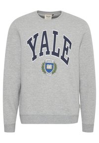 Sudadera gris con "YALE" en color marino, con un escudo universitario en el centro, puños de canalé y cuello redondo.