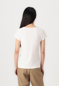 T-shirt bianco a maniche corte realizzato in morbido cotone, con scollo a girocollo e vestibilità comoda, mostrato dal retro.