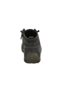 Zapato de cuero negro de tobillo con costuras en contraste, con punta redondeada y tacón bajo, que presenta un cierre lateral y una superficie texturizada.