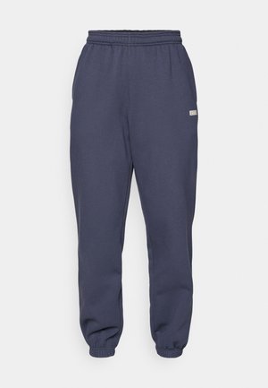 Navy blue sweatpants made of soft material; features an elastic waistband and cuffs, with a small label on the side.