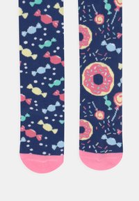 Marine sokker med et fargerikt mønster av godteri og donuts; ensfargede rosa tær; laget av mykt, elastisk materiale; designet for komfort og stil.