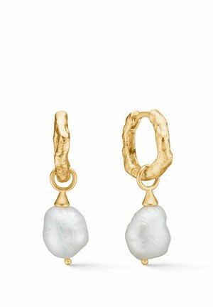 Kolczyki koła w złotym odcieniu z teksturowanym wzorem, na których zawieszone są nieregularne białe perły barokowe.