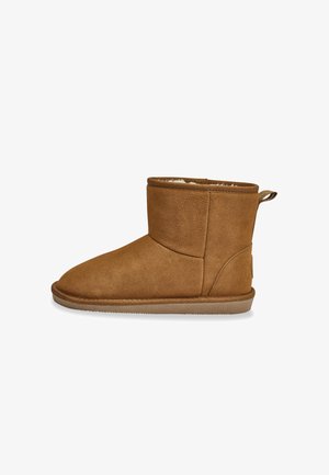 Stivale alla caviglia in suede marrone con un morbido rivestimento interno, design minimalista, punta rotonda e una linguetta sul retro per indossarlo facilmente. Suola piatta in gomma.