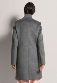 Grijze wollen jas met een hoge kraag, lange mouwen, aangesloten pasvorm en rechte snit, met een minimalistisch ontwerp en geen zichtbare sluitingen.