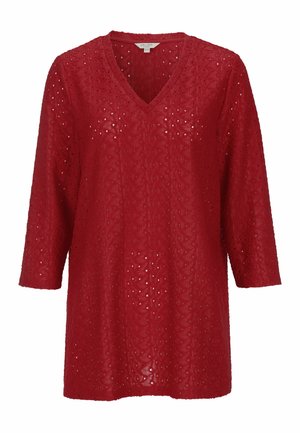 Röd tunika med V-halsringning, trekvartslånga ärmar och en texturerad design med hålmönster genom hela plagget. Avslappnad passform, lättviktsmaterial.