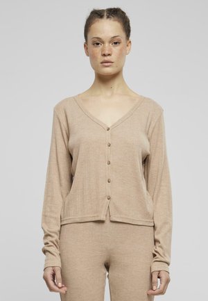 Gilet beige côtelé avec un col en V, des manches longues et six boutons à l'avant. Tissu texturé se prolonge jusqu'à un bas assorti beige.