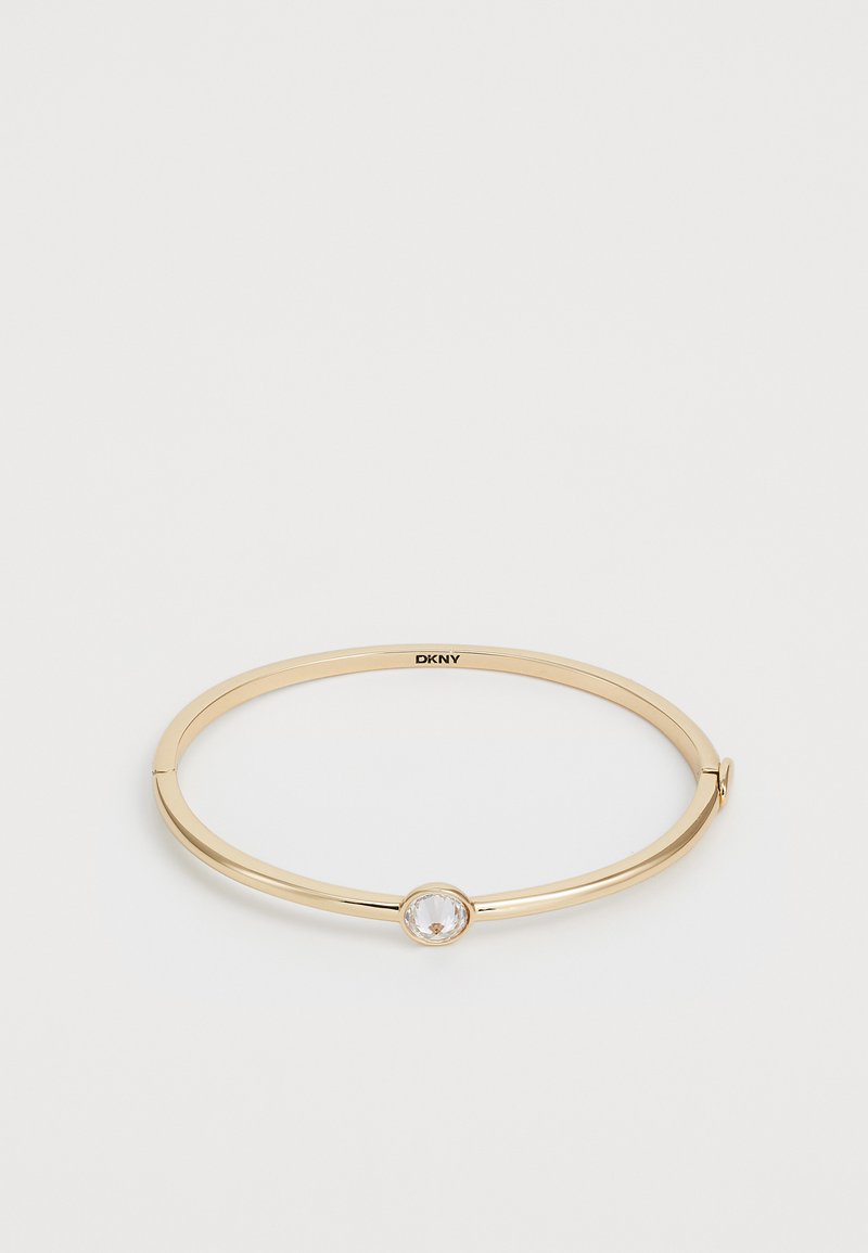 Gouden metalen bangle armband met een ronde heldere steen in het midden, een gladde afwerking en een minimalistisch ontwerp met een scharnier sluiting.