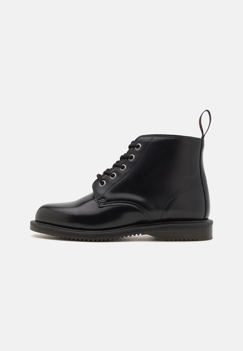 Botas negras de cuero hasta el tobillo con punta redonda, que cuentan con seis ojales, cordones planos, un tacón bajo y una lengüeta en la parte trasera.
