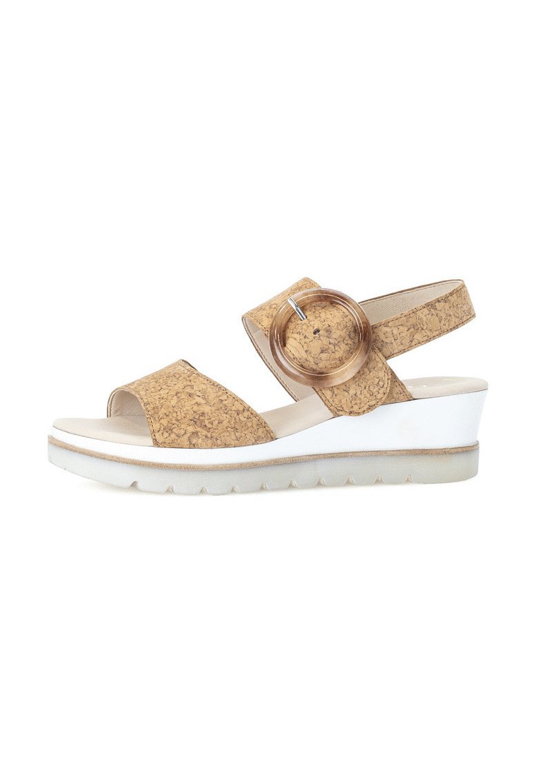 Cork wedge sandals with a round, clear accent, open toe, and elastic strap. White sole with subtle tread pattern; light tan color.