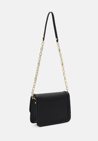 Svart axelväska i texturerat material med rektangulär form, utrustad med ett guldkedjestras och en elegant design.