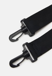 Black nylon strap with adjustable clips and hooks. Flat texture with sturdy stitching and plastic hardware for secure attachment.