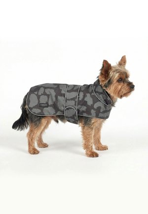 Malý pes s hnedou a čiernou srsťou nosiaci sivý kabátik s maskáčovým vzorom, golierom a bočným zapínaním.