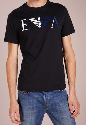 Czarny bawełniany T-shirt z graficznym nadrukiem liter "EVA" w białe, niebieskie i teksturowe paski. Krótkie rękawy, okrągły dekolt.