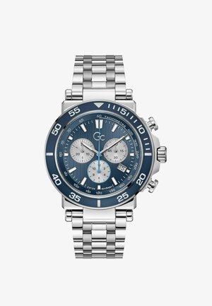 Strieborné nerezové hodinky s modrým ciferníkom, tromi subciferníkmi, tachymetrickým rádiusom a prepojeným dizajnom náramku. Biely ukazovateľ hodín a ručičky.