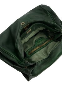 Green leather handbag with a soft texture, featuring an unfastened zip closure, fabric lining, and an inner zip pocket.