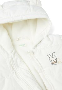 Bílá prošívaná puffer bunda s měkkou fleecovou podšívkou. Má kapuci, roztomilou výšivku králíčka a plný zip.