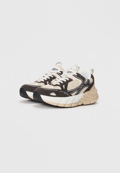 Tjocka sneakers med en mörkbrun och krämfärgad design, som har en blandning av mocka och nät, runda tår och framträdande vita snören.
