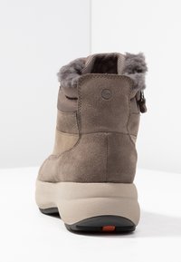 Brune suedeboot med ankellærem, tekstureret overdel, blødt for og lynlåslukning. Har en tyk, lys farvet sål med et orange akcent.