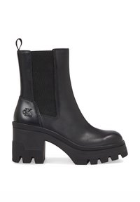 Botas de tobillo de cuero negro con paneles elásticos laterales, tacón de goma grueso y suela detallada. Presenta un acento de logo en el tacón.