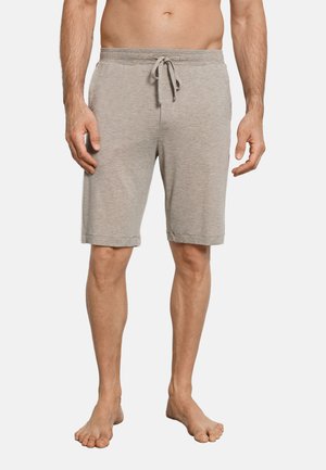 Man draagt lichtgrijze kniebroek met trekkoord en staat blootsvoets tegen een witte achtergrond.