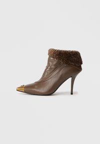Browns ādas potītes zābaks ar pūkainu brūnu malējo daļu, smailu purngalu ar metālisku zelta galu un stiletto papēdi.