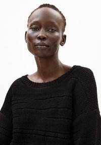 Black knit sweater featuring a textured design with horizontal lines, round neckline, and relaxed fit. Smooth fabric with subtle detailing.