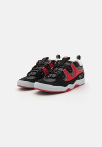 Zapatillas deportivas negras y rojas con paneles de malla, suela de goma y acentos blancos en contraste. Cuenta con cordones y tiradores para facilitar su uso.