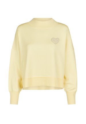 Pale yellow long-sleeve sweater with ribbed high neck, cuffs, hem, and a pearl heart embellishment on the left chest.