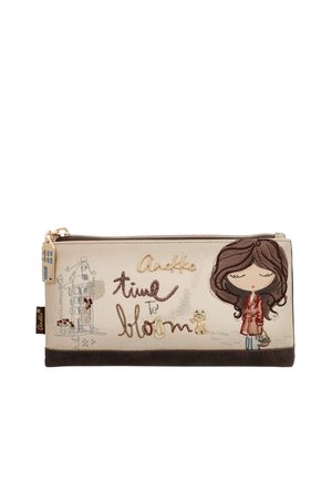 Bolsa beige con ilustración de una niña sosteniendo flores, un pequeño gato, un boceto de una casa y texto que dice "Anekke time to bloom" en fuente decorativa.