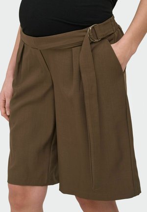 Brązowe szorty z wysokim stanem, plisami, bocznymi kieszeniami i materiałowym paskiem z okrągłą złotą klamrą, noszone z czarnym topem.