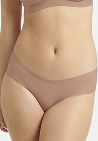 Hellbraune nahtlose Unterwäsche mit glatter Textur und niedrigem Schnitt. Verfügt über ein dezentes Markenlogo am Bund.