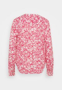 Blusa a maniche lunghe con un motivo floreale rosso e bianco, realizzata in tessuto leggero, con scollatura rotonda e dettagli con bottoni.