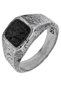 Sudraba gredzens ar strukturētu joslu, liela melna akmens augšpusē un kvadrātas formas dizainu ar raupju, detalizētu virsmu rakstiem.