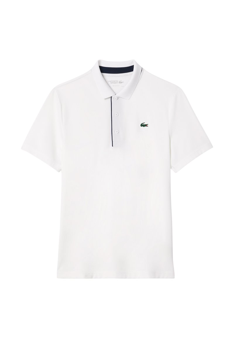 Polo blanc en tissu léger, avec une patte de boutonnage à trois boutons, un col bleu marine et un petit logo de crocodile vert sur la poitrine.