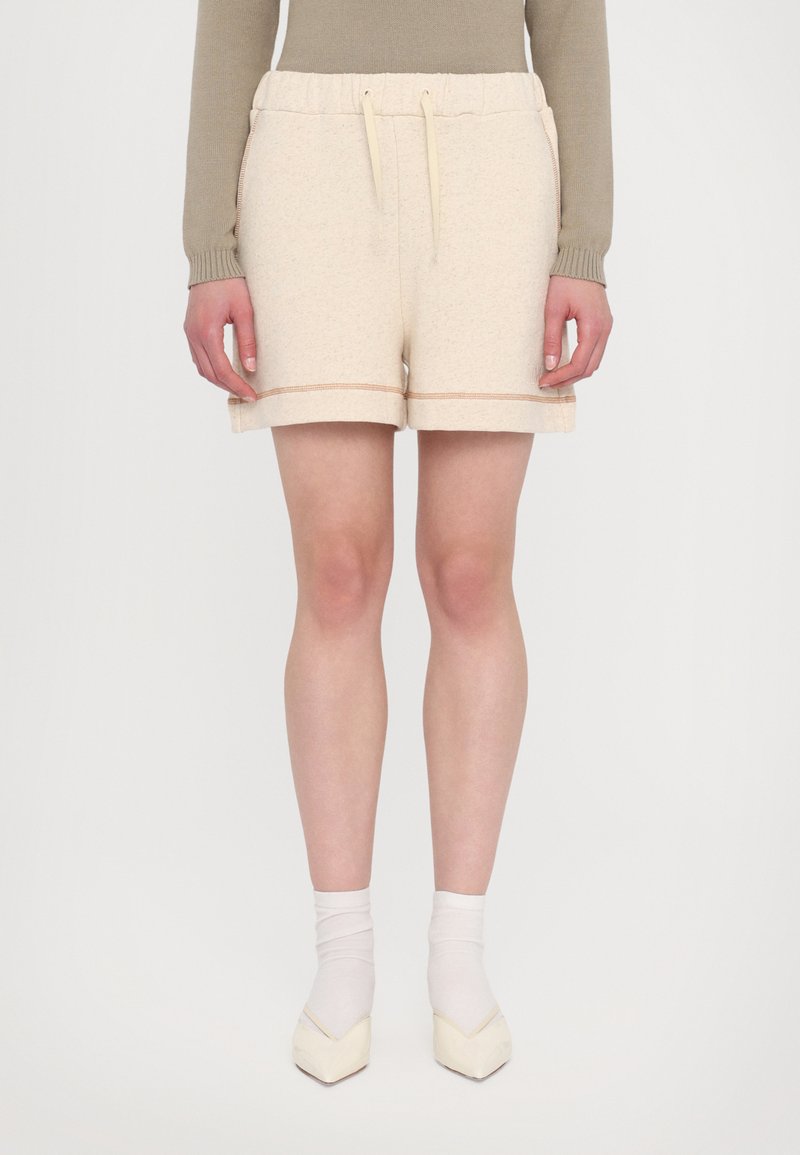 Lys beige bomull-blanding shorts med elastisk midjebånd og snor. Har oppbrettede sømmer med dekorativ brodering. Glatt tekstur.