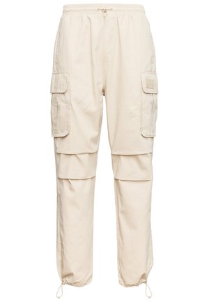 Beige cargo pants with elastic waistband, multiple side pockets, and ankle drawstrings. Made from lightweight fabric with a smooth texture.