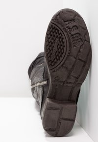 Black leather ankle boot with textured surface, visible zipper, and patterned rubber sole. Size 37 marked on the bottom.