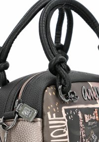 Schwarze Handtasche aus Leder mit strukturierten Oberflächen, runder Form und doppelten Griffen. Verfügt über einen metallischen Reißverschluss und dekorative Akzente in Farben.