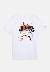 Bijela pamučna majica s bold grafikom košarkaša koji zakucava, s crvenim, crnim i žutim akcentima te Nike logom.